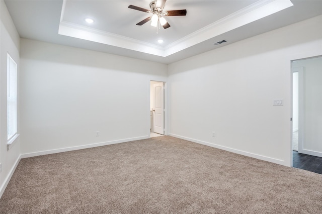 carpeted empty room featuring ceiling fan, ornamental molding, and a raised ceiling