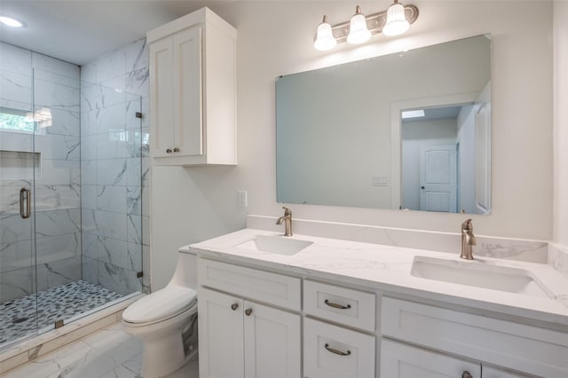 bathroom featuring a shower with shower door, vanity, and toilet