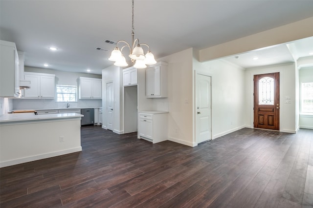 kitchen featuring white cabinetry, dark hardwood / wood-style floors, decorative light fixtures, and a notable chandelier