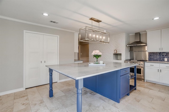 kitchen with decorative light fixtures, stainless steel range, white cabinets, and wall chimney exhaust hood