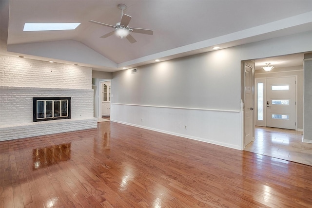 unfurnished living room with ceiling fan, a fireplace, and hardwood / wood-style flooring