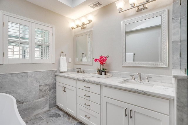 bathroom featuring a bath, tile walls, and vanity