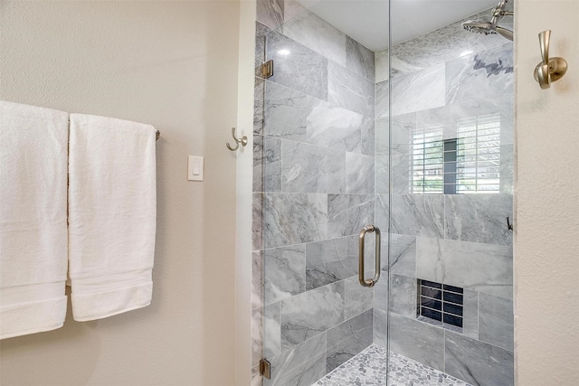 bathroom featuring a shower with door