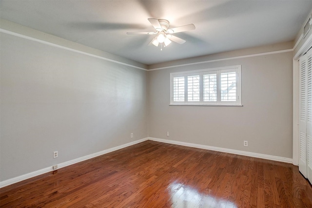 unfurnished bedroom featuring ceiling fan, dark hardwood / wood-style floors, and a closet