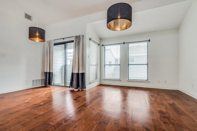 spare room with lofted ceiling and dark hardwood / wood-style floors