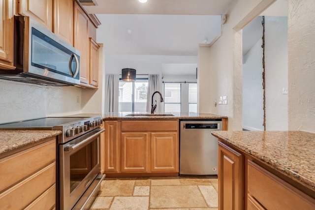 kitchen with light stone countertops, sink, and stainless steel appliances