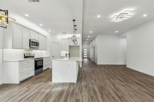 kitchen featuring decorative light fixtures, sink, white cabinetry, an island with sink, and stainless steel appliances