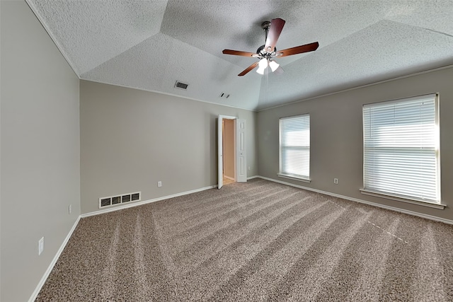 unfurnished bedroom featuring a textured ceiling, carpet floors, vaulted ceiling, ceiling fan, and crown molding