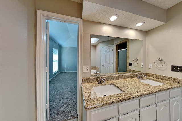 bathroom with a textured ceiling, walk in shower, and vanity