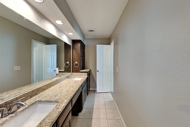 bathroom featuring vanity, tile patterned floors, and a textured ceiling