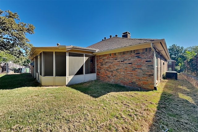 back of property with a sunroom and a yard