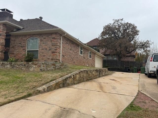 view of side of property featuring a garage and a yard