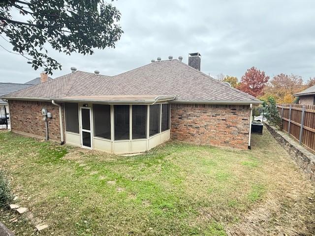 rear view of house with a sunroom, a lawn, and cooling unit