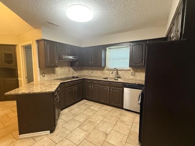 kitchen with a textured ceiling, black appliances, decorative backsplash, sink, and kitchen peninsula