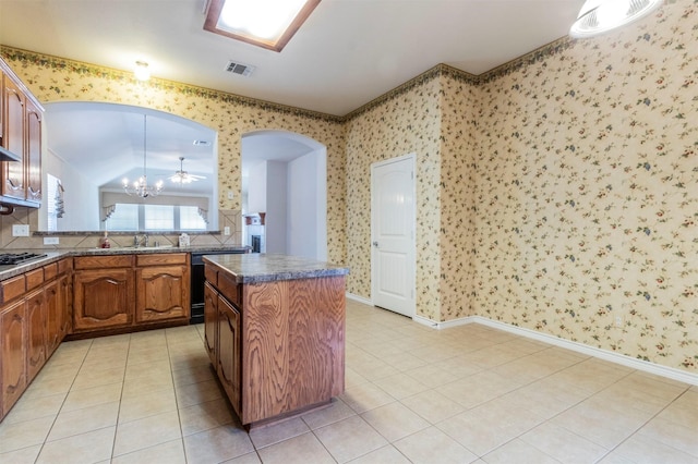 kitchen with decorative light fixtures, light tile patterned floors, a center island, and stainless steel gas stovetop