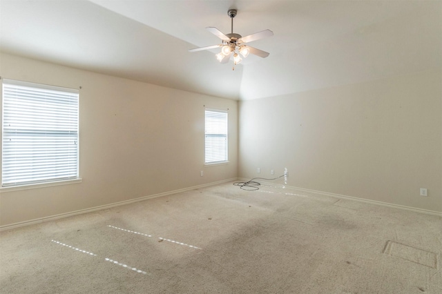 carpeted empty room featuring ceiling fan and vaulted ceiling