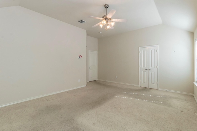 empty room with vaulted ceiling, ceiling fan, and light colored carpet