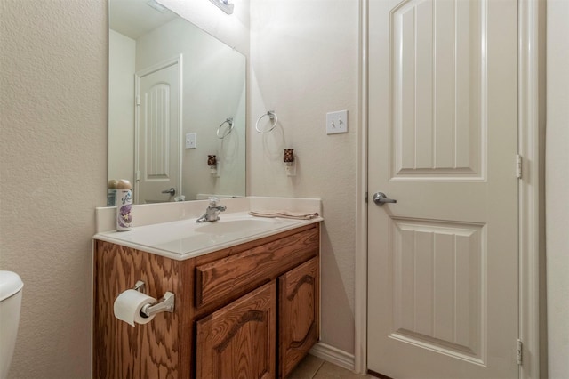 bathroom featuring toilet, vanity, and tile patterned flooring