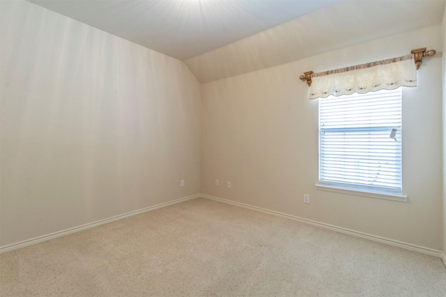 empty room featuring lofted ceiling and carpet