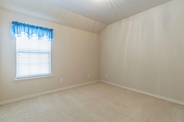 unfurnished room with vaulted ceiling