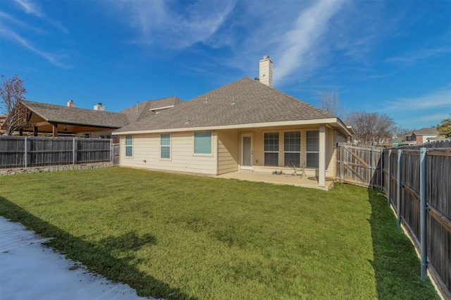 back of house featuring a patio area and a lawn