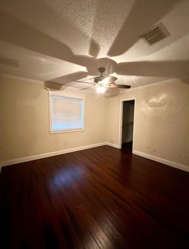 additional living space featuring dark wood-type flooring, ceiling fan, and a textured ceiling