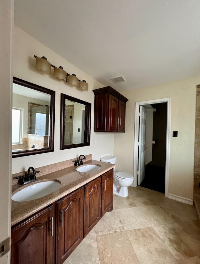 bathroom with vanity, toilet, and a shower