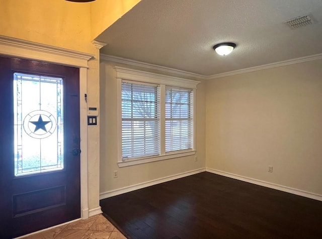 foyer with hardwood / wood-style flooring, ornamental molding, and a textured ceiling