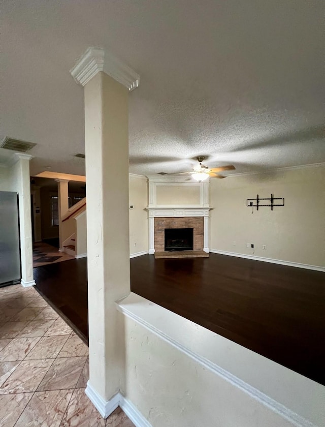 unfurnished living room with crown molding, ceiling fan, and a textured ceiling