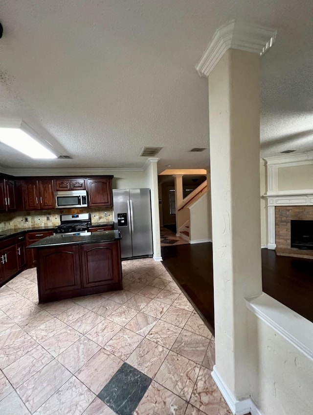 kitchen featuring tasteful backsplash, dark brown cabinetry, appliances with stainless steel finishes, and a textured ceiling