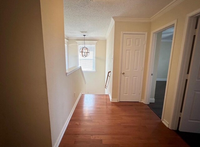 hall with crown molding, dark hardwood / wood-style floors, and a textured ceiling