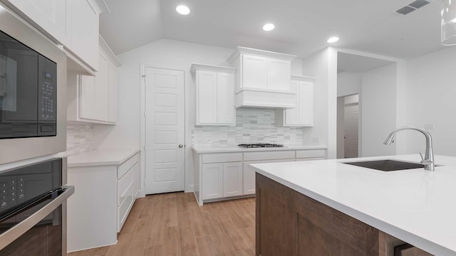 bathroom featuring a bath, walk in shower, two vanities, a sink, and marble finish floor