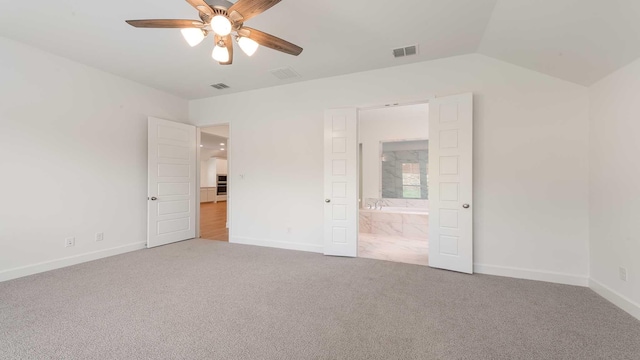 unfurnished bedroom featuring visible vents, carpet, baseboards, and lofted ceiling