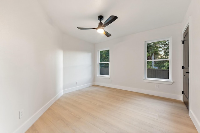 empty room with ceiling fan and light hardwood / wood-style flooring