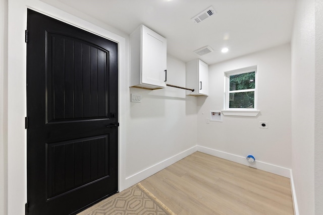 laundry area with light wood-type flooring, cabinets, hookup for a washing machine, and hookup for an electric dryer