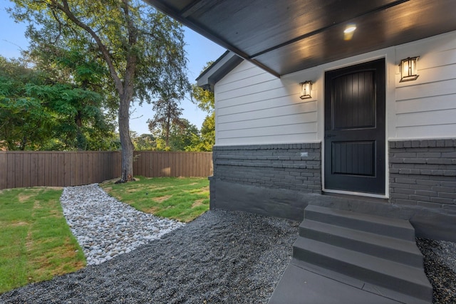 view of exterior entry featuring a yard