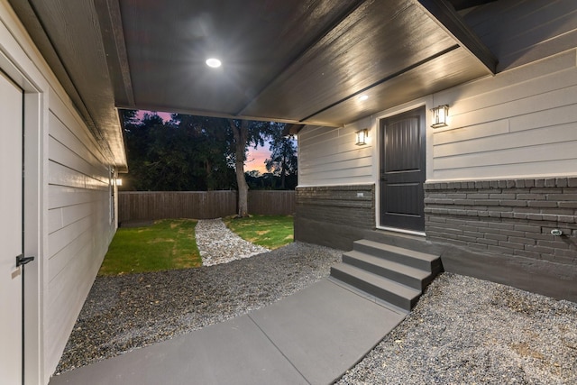 exterior entry at dusk featuring a patio