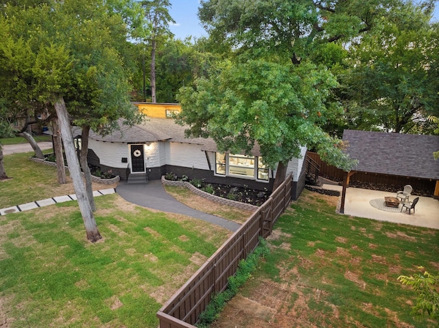 view of front facade with a front yard, an outdoor fire pit, and a patio