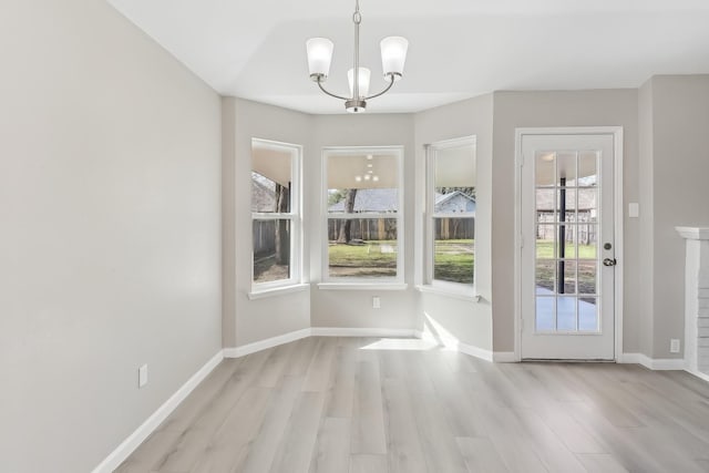 unfurnished dining area featuring light hardwood / wood-style flooring and a notable chandelier