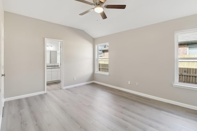 unfurnished bedroom featuring ensuite bathroom, ceiling fan, vaulted ceiling, light hardwood / wood-style flooring, and sink