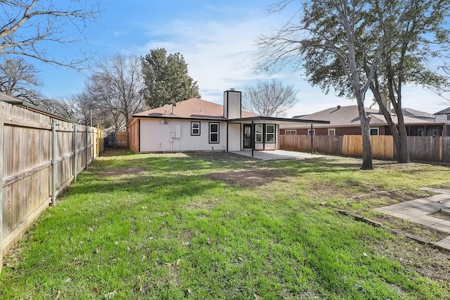 rear view of property featuring a lawn and a patio area