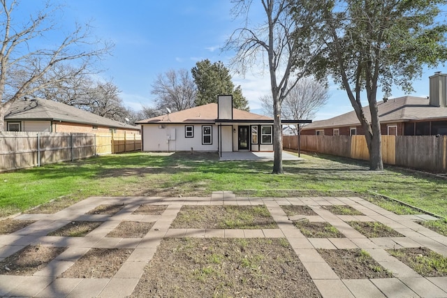 rear view of property featuring a yard and a patio