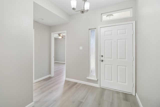 entrance foyer with ceiling fan with notable chandelier and light hardwood / wood-style floors