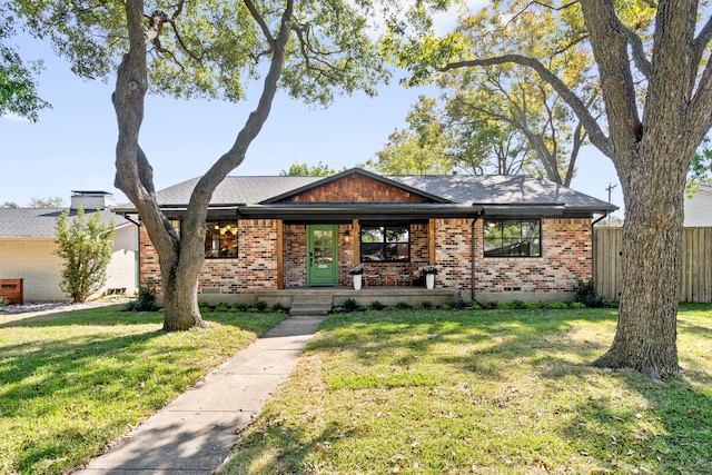 ranch-style house featuring covered porch and a front yard