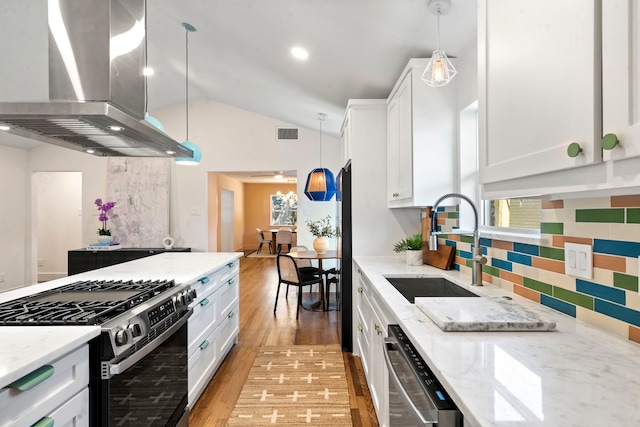 kitchen with island range hood, stainless steel appliances, vaulted ceiling, pendant lighting, and white cabinets