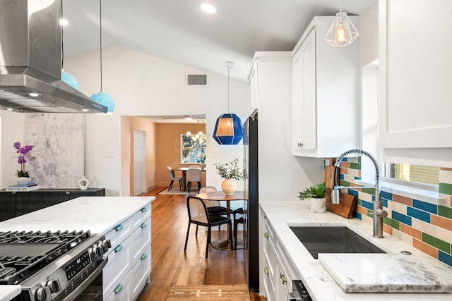 kitchen featuring decorative light fixtures, island exhaust hood, sink, and white cabinets