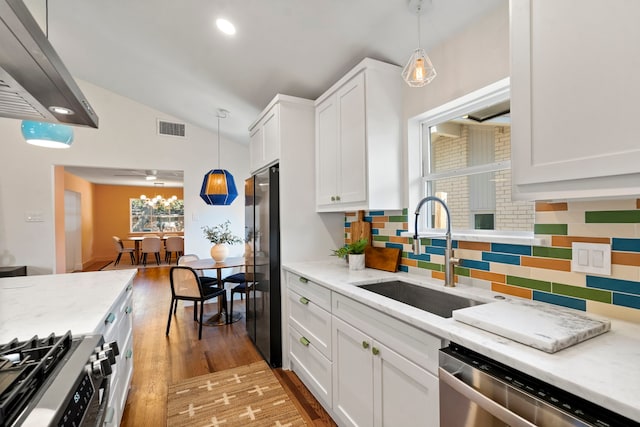 kitchen with appliances with stainless steel finishes, backsplash, pendant lighting, white cabinets, and sink