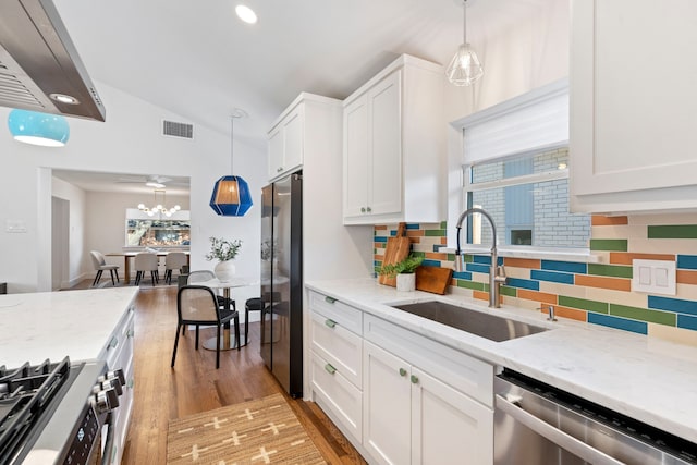 10414 Robindale Dr, Dallas, TX 75238 - kitchen with visible vents, white cabinets, vaulted ceiling, stainless steel appliances, and a sink