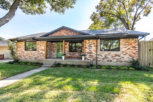 ranch-style house featuring covered porch and a front lawn