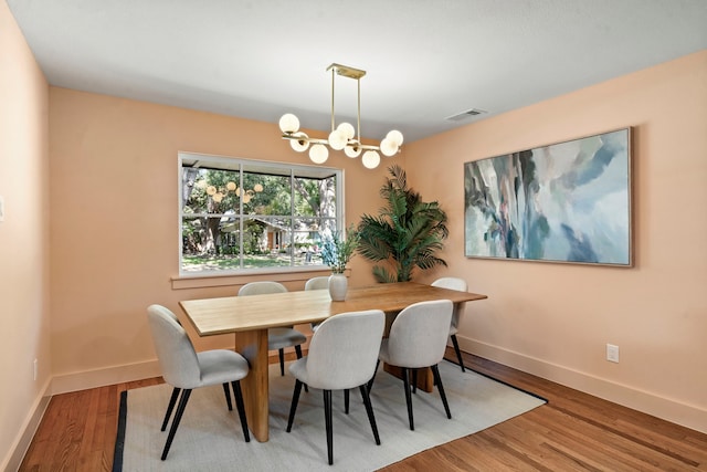 dining space featuring hardwood / wood-style floors and a notable chandelier